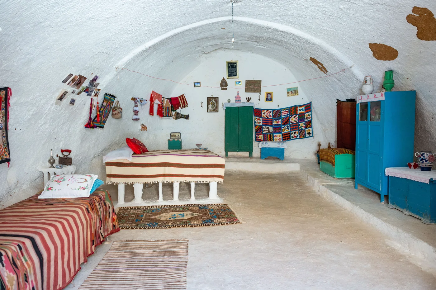 Det hvidkalkede interiør i en Sacromonte-hule med kobbergryder på væggen