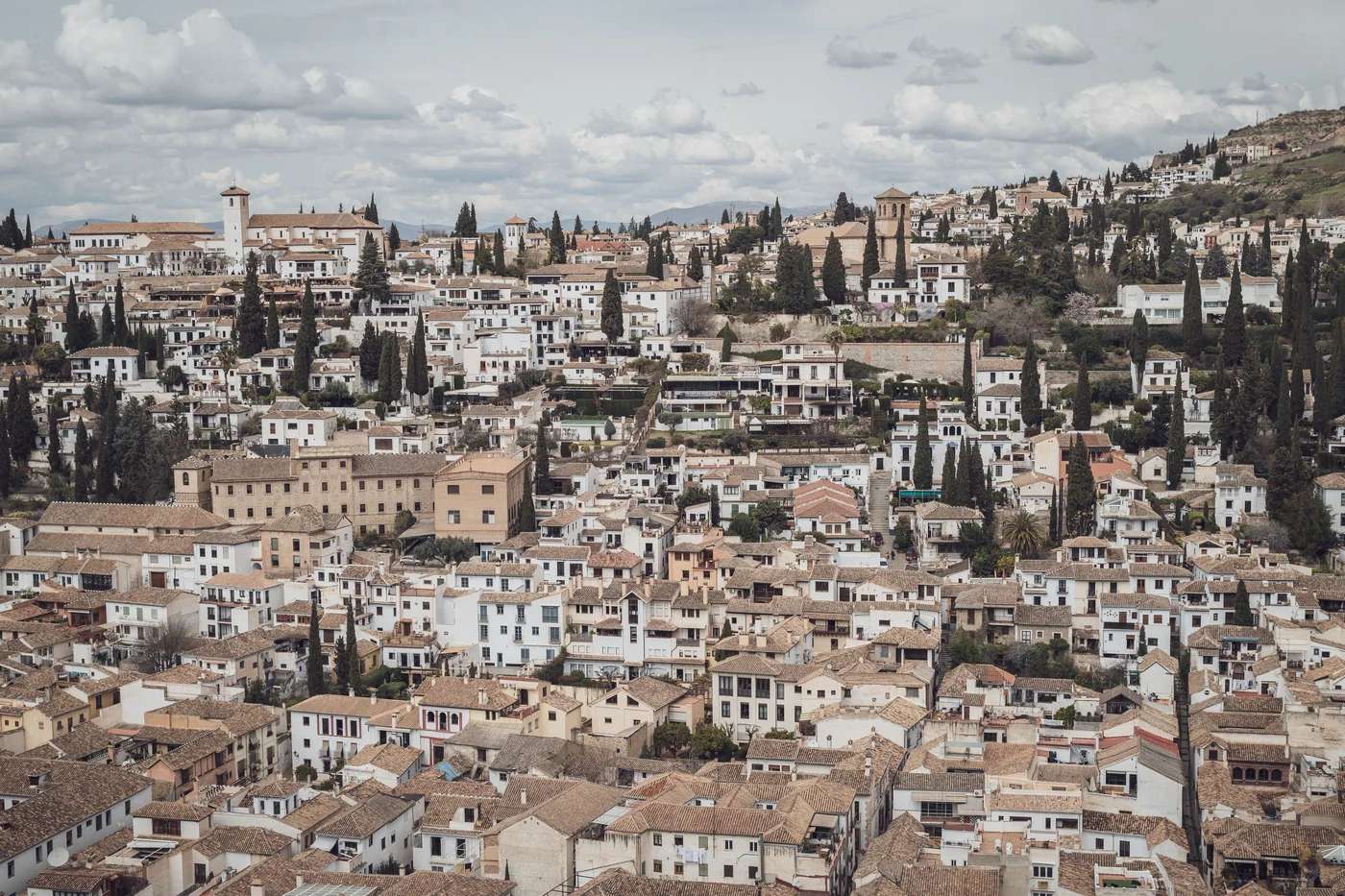 Hvidkalkede hulehuse på Sacromonte-bjergsiden med Alhambra i baggrunden